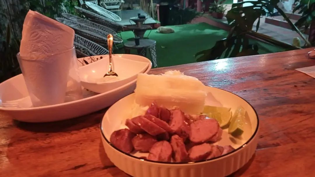 Chorizo en rodajas con limón y un acompañante, servido de noche en la barra.