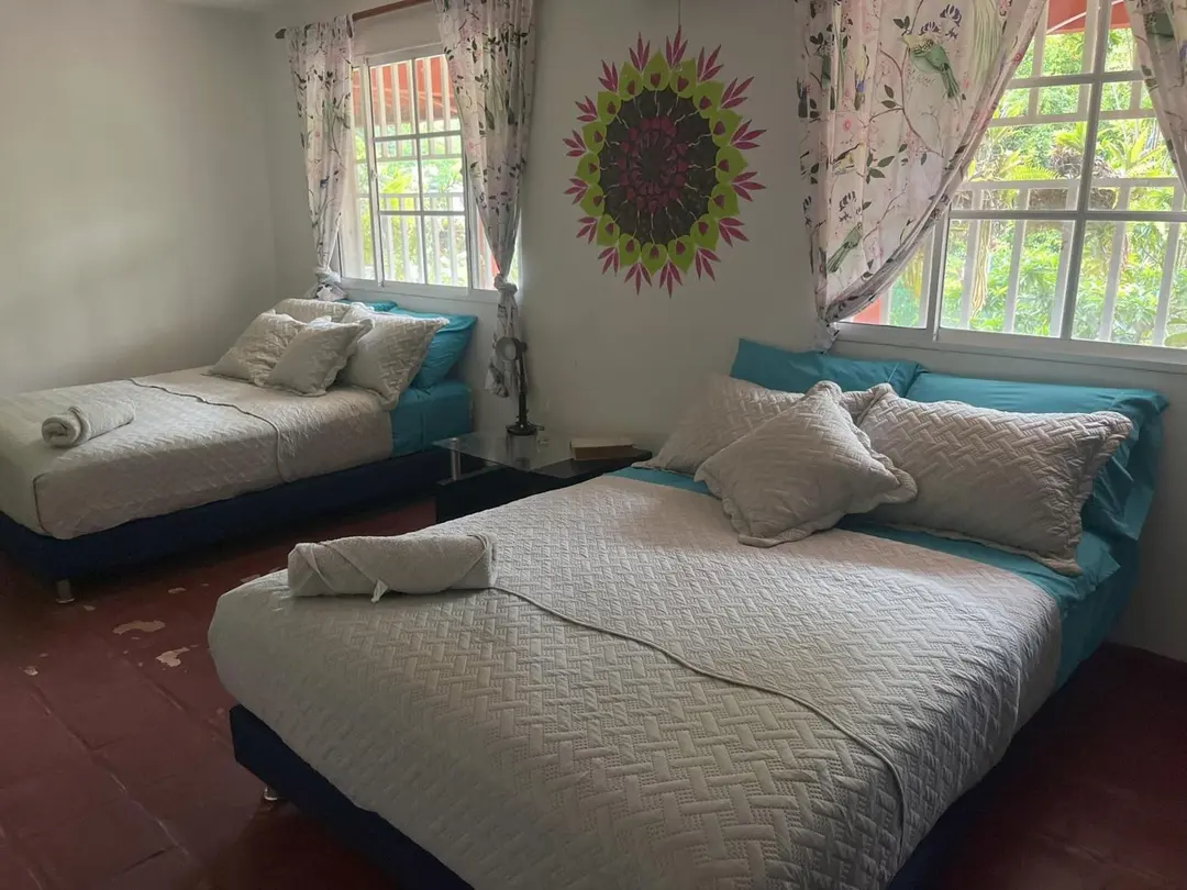 La habitación del mandala con una cama doble y una cama junto a la ventana.